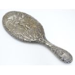 A silver backed hand mirror with moth, acanthus and cherub decoration. Hallmarked Chester 1901 maker