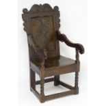 A 17thC oak Wainscot chair with a scrolled and carved cresting rail above a highly decorative and