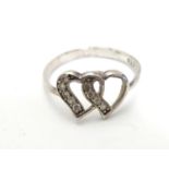 A silver ring with open heart detail to top set with white stones. Ring size approx O Please