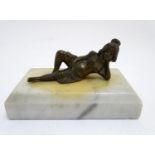 A 20thC paperweight of rectangular form, decorated with a cast model of a reclining woman on a