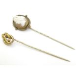 A gilt metal stick pin surmounted by a cameo together with a gilt metal stick pin with knot