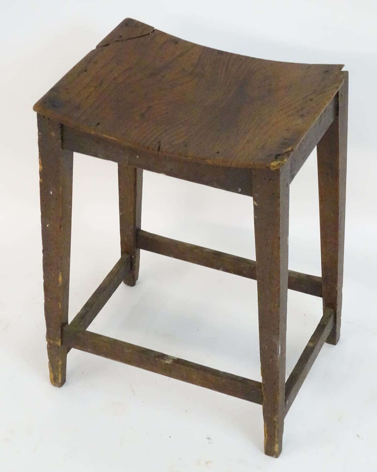 An 18thC elm stool with a bowed top above squared tapering legs and united by a box stretcher. 14?