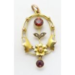 An Art Nouveau pendant set with garnets and seed pearls. Approx 1 1/4" long Please Note - we do