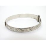 A silver bracelet of bangle form with engraved decoration Hallmarked Birmingham 1975 maker Henry