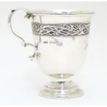 A Silver mug decorated with a frieze bearing Art Nouveau / Arts and crafts design, raised on a