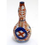 An Oriental miniature double gourd vase decorated in the Imari palette. Approx. 3 3/4" Please Note -