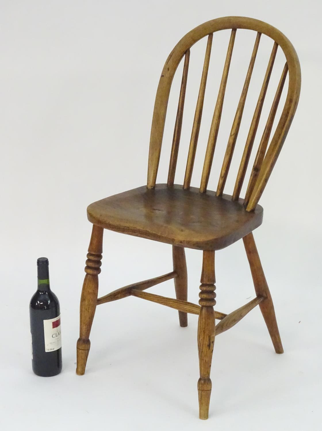 A 19thC elm childs Windsor chair with bowed back and stick supports above a shaped seat and raised - Image 3 of 4