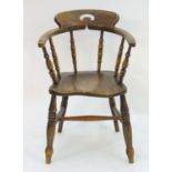 A 19thC smokers bow chair with a pierced top rail, curved backrest with turned supports above an elm