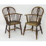 Two early 19thC ash and elm double bow back Windsor chairs with pierced back splats above shaped