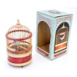 A late 20thC automaton formed as a bird in a bird cage. In original box. Box approx. 7" high