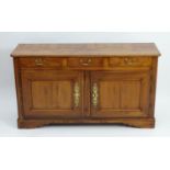 A French cherry wood buffet / serving cabinet with a figured top above three short drawers with