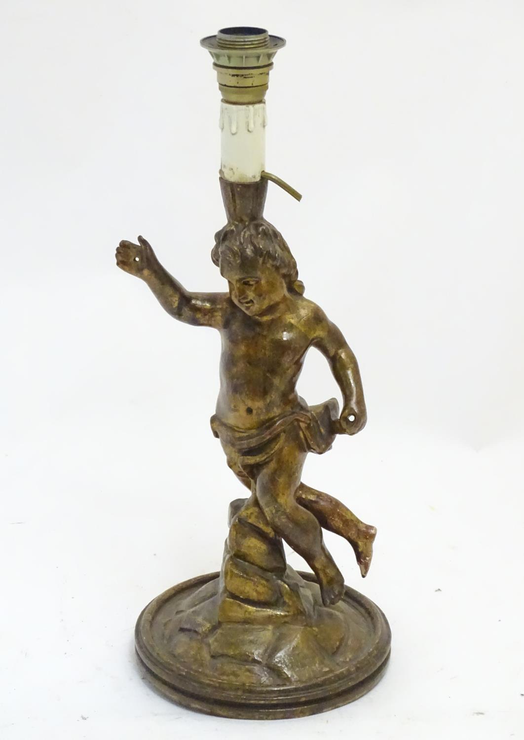 A 20thC Italian carved wooden lamp, formed as a putto with gilt finish and circular base, 21 1/4"