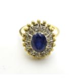 An 18ct gold ring set with central sapphire bordered by white stones. Ring size approx Q 1/2