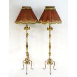 A pair of late 19th / early 20thC wrought iron standard lamps, with gilt finish, foliate