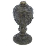 A 19thC cast oil lamp base decorated in relief, the top with stacked arms, helmets, shields, bow and