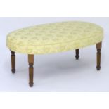 An early 21stC footstool with an oval upholstered top above six reeded tapering legs. 36" long x 23"