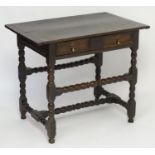 A mid / late 17thC oak side table with a proud top above a single long drawer with moulded