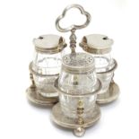 A Victorian silver cruet stand with three glass bottles of barrel form with silver mounts.