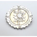 A Victorian silver brooch of circular form with floral detail. Hallmarked Birmingham 1890 maker