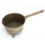 An 18thC Irish bronze skillet pan, the handle with reeding and marked 'IH4', standing on three legs,