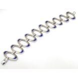 A Continental .835 silver retro bracelet the shaped open work links with blue enamel decoration