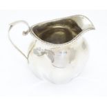 A silver cream jug of quatrefoil form, the rim with gadrooned decoration. Hallmarked Birmingham 1903