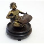 A Japanese bronze modelled as a seated fishmerman with a large fish, with an associated wooden base.