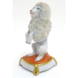 A Continental model of a seated begging poodle dog. Marked under with crown and S. Approx. 3" high