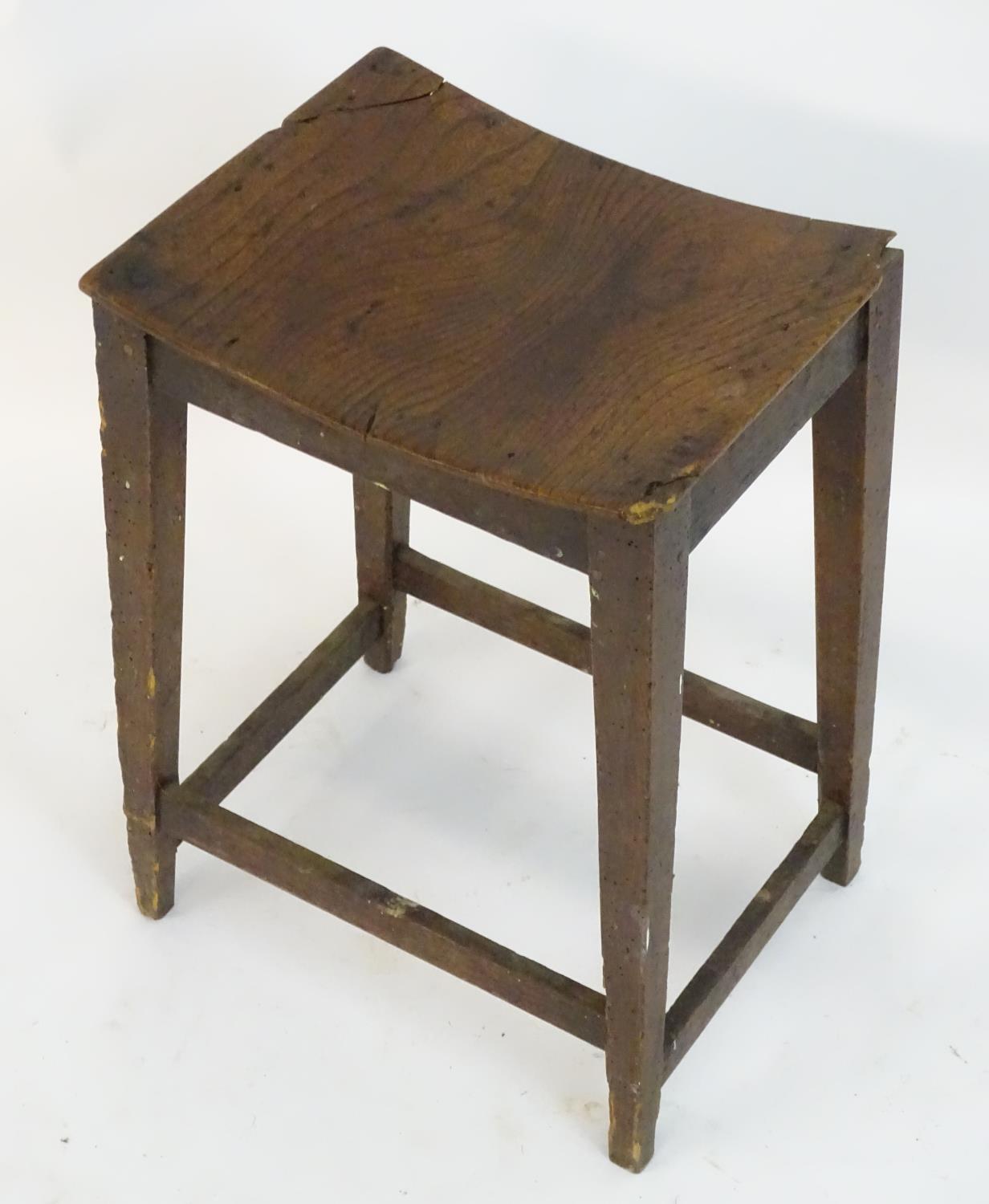 An 18thC elm stool with a bowed top above squared tapering legs and united by a box stretcher. 14? - Image 4 of 4
