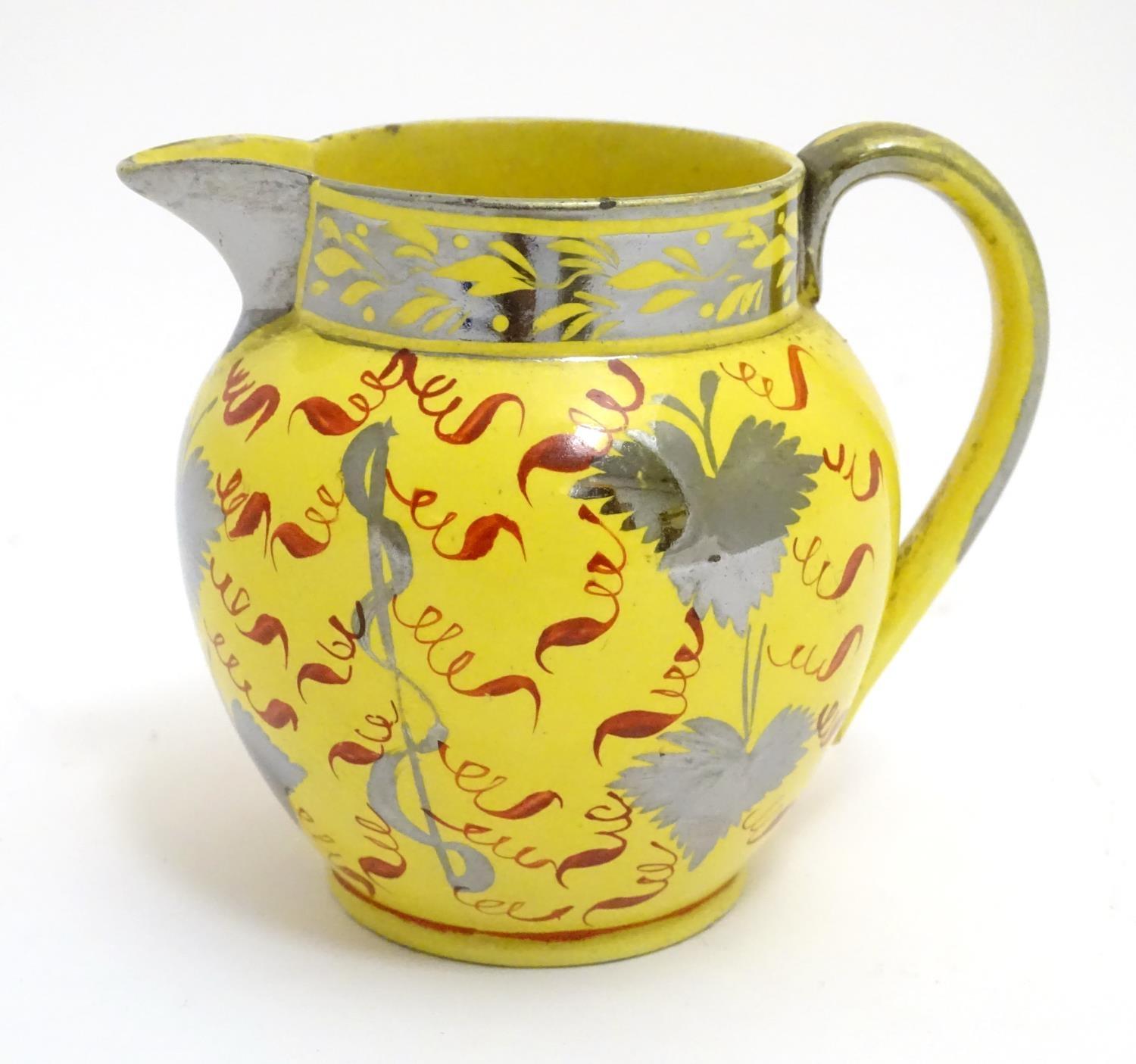 A 19thC canary yellow Sunderland lustre cream jug with stylised lustre leaf and foliate