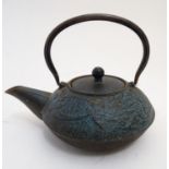 A 20thC Japanese cast iron teapot with swing handle, decorated with a fire breathing imperial dragon