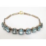 An early 20thC 9ct gold bracelet set with 9 blue zircon. Please Note - we do not make reference to