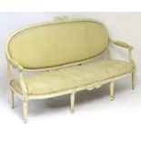 A late 19thC Louis XVI style sofa with a carved cresting rail above an upholstered back rest and