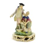 A Continental porcelain figural group depicting a shoe shine girl shining a gentleman's shoes in a