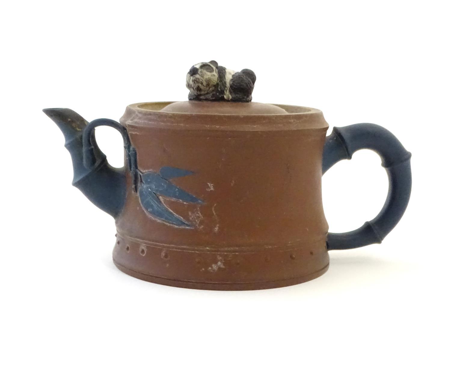 A Chinese clay teapot, the handle and spout modelled as stylised bamboo, the lid surmounted by a