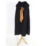 A bespoke vintage ladies black evening cape, with padded collar, tie to neck. Bronze/orange