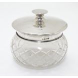 A cut glass powder bowl with silver lid hallmarked Birmingham 1922 maker Charles S Green & Co Ltd.