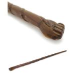 An early 20thC Australian blackwood walking cane, the knop formed as a clenched fist holding a