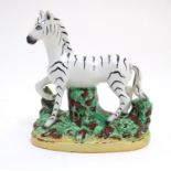 A Staffordshire figure modelled as a zebra on a naturalistic oval base. Approx. 4 3/4" high Please