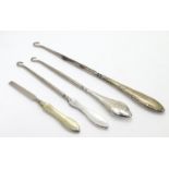 Three assorted button hooks with silver handles together with a manicure tool. The largest 8 3/4" (