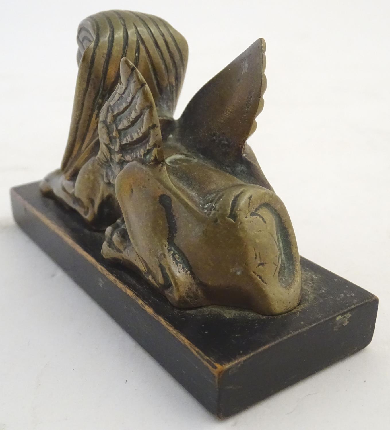 A 20thC paperweight formed as a winged sphinx with the head of a pharaoh on a rectangular wooden - Image 6 of 7