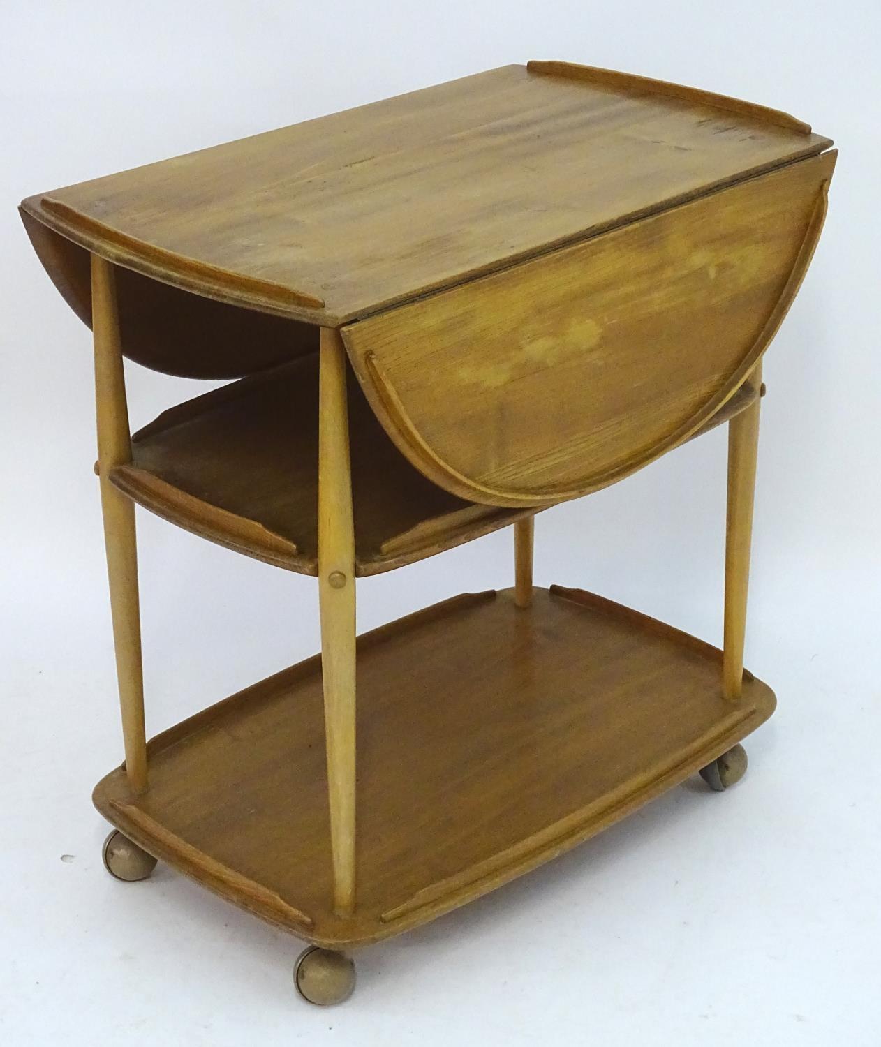 Vintage Retro, Mid-Century: an Ercol elm and beech three tiered trolley, the top with drop flaps,