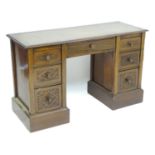 A late 19thC / early 20thC double pedestal desk with an inset leather top above a central long