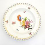 A 19thC porcelain soup dish with hand painted flower detail and gilt highlights. Approx. 10"
