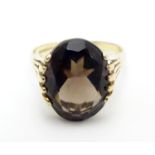 A 9ct gold ring set with central oval smoky quartz in a claw setting. Ring size approx M Please Note