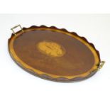 A late 19th / early 20thC oval mahogany tray with twin brass handles and central satinwood inlay