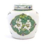A Chinese famille verte ginger jar and cover with panelled decoration depicting figures with