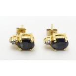 A pair of silver gilt stud earrings set with blue and white stones. Approx. 3/8" long Please
