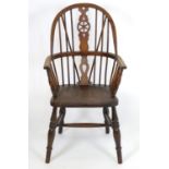 A 20thC Windsor armchair with an elm seat and double bow back with pierced back splat, the chair