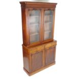 A mid 19thC glazed mahogany bookcase with a moulded cornice above four shelves. The glazed doors